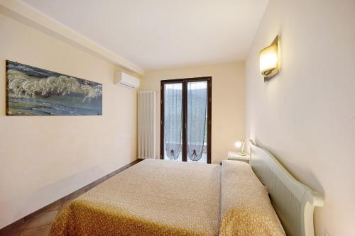 Molino NuovoBelfast Agriturismo La Scuderia的一间卧室设有一张床和一个窗口