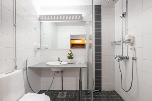 TuulosHotel Tuulonen的浴室配有盥洗盆和带镜子的淋浴