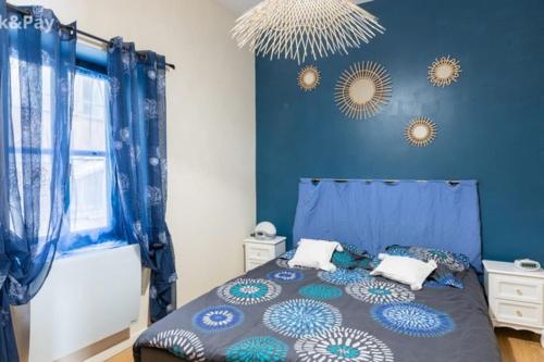 贝济耶Cauquilha SPACIEUX APPARTEMENT BOURGEOIS EN CENTRE VILLE的蓝色卧室,配有蓝色墙壁的床