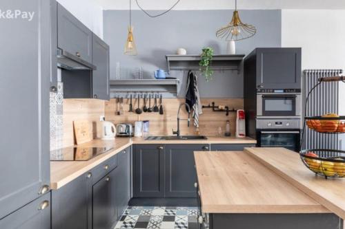 贝济耶Cauquilha SPACIEUX APPARTEMENT BOURGEOIS EN CENTRE VILLE的厨房配有蓝色橱柜和木制台面