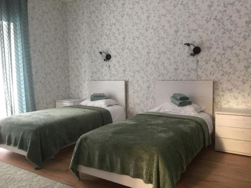 Allika külalistemaja的一间卧室配有两张带绿毯的床