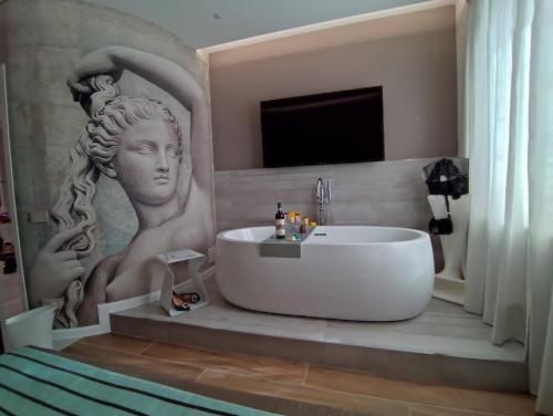 罗马il sogno di afrodite luxury b and b的带浴缸的浴室和一幅女子画
