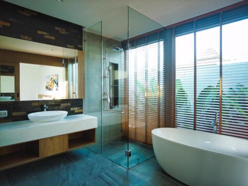 邦涛海滩Bliss Villa at Shambhala Grand的带浴缸、水槽和镜子的浴室