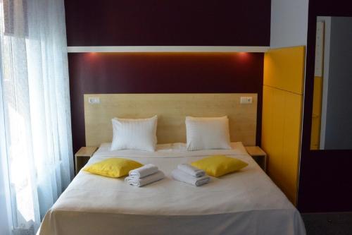 尤尔马拉阿尔巴酒店的一间卧室配有带毛巾的床