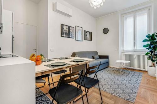 米兰New Milan Central Apartment的厨房以及带桌椅的起居室。