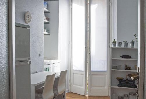 米兰Liberty Two-Room Apartment in Porta Venezia的一间配备有白色桌椅的用餐室