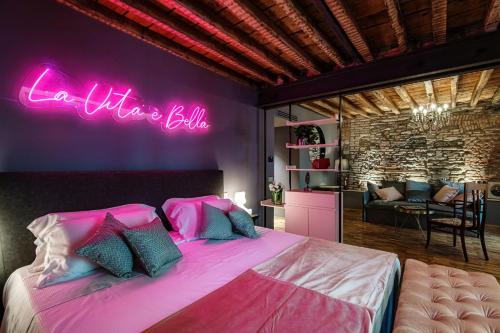科莫Vitrum - Como Luxury Suites的一间卧室配有一张带 ⁇ 虹灯标志的大床