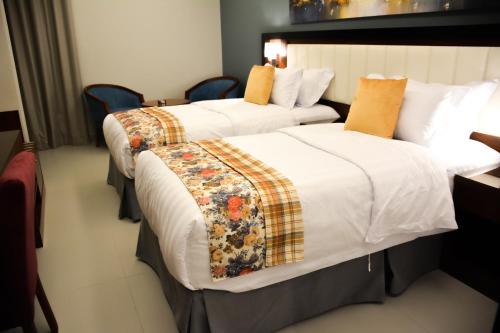 吉达Park Town的配有2张床铺的酒店客房,提供白色床单和橙色枕头