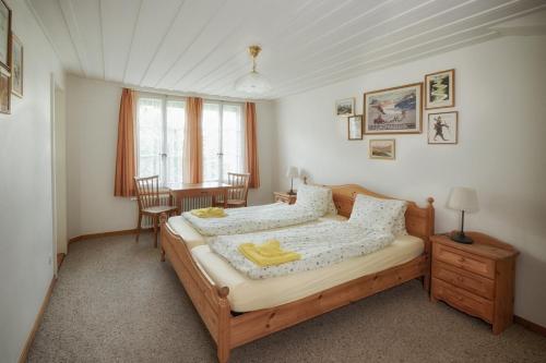 因特拉肯历史城市木屋酒店的卧室配有一张床和一张桌子及椅子