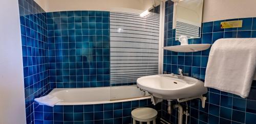 沙托鲁博伊查特斯涛特尔酒店的蓝色瓷砖浴室设有水槽和浴缸