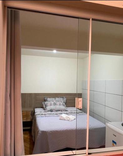 特雷齐蒂利亚斯Hospedaria São José的一间卧室配有一张玻璃墙床