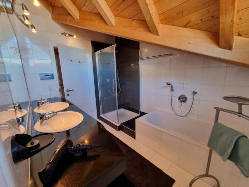 耶岑斯Alpenapart Schultes Sports的浴室配有2个盥洗盆和1个浴缸。