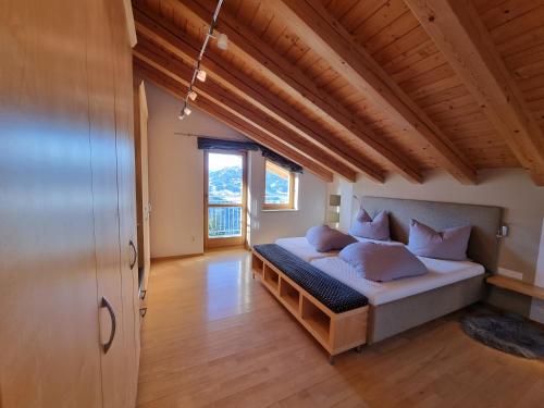 耶岑斯Alpenapart Schultes Sports的一间带一张床的卧室,位于带木制天花板的房间内