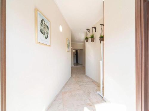 庞贝POMPEI FELIX的走廊设有白色墙壁和瓷砖地板