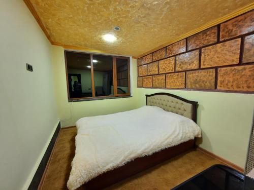 ZarritʼapʼPhoenix Villa的一间卧室设有一张床和砖墙