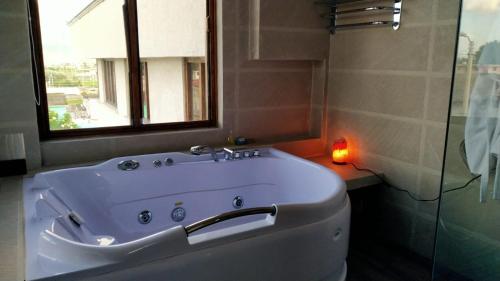 Machachi萨基瓦酒店的带浴缸、窗户和蜡烛的浴室