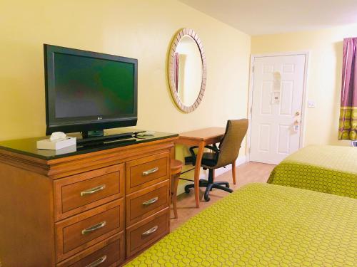 克利夫兰Classic Suites - Cleveland的一间卧室,配有带书桌的梳妆台和电视机