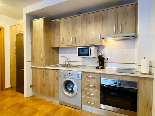 卡索拉Casa RIVERSIDE - Cazorla的厨房配有洗衣机和微波炉。