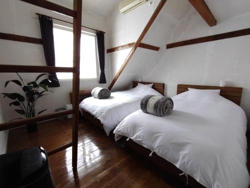 白马村Keimichi Guest House的带窗户的客房内设有两张单人床。