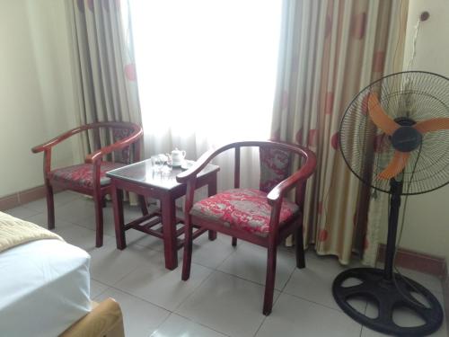 太原省Khách sạn Sơn的客房设有两把椅子、一张桌子和风扇。