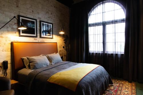 惠灵顿The Intrepid Hotel的一间卧室设有一张床和一个大窗户
