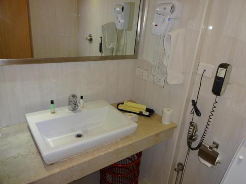 钦奈萨维拉酒店的一间带水槽的浴室和墙上的一部电话