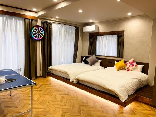 福冈TABISAI HOTEL Suite 博多的一间卧室设有两张床、一张桌子和窗户。