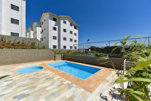 布拉干萨-保利斯塔D01 Apto com estacionamento, piscina e churrasqueira的一座建筑后院的游泳池