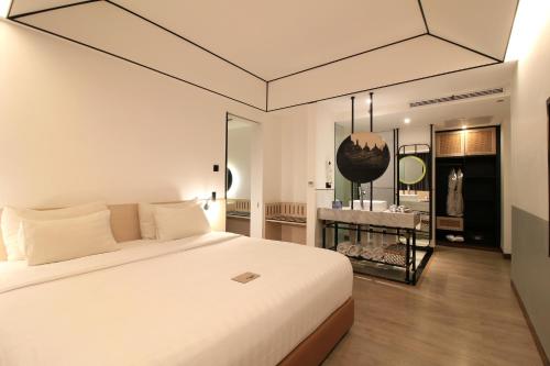 日惹盖亚科兹摩酒店的卧室配有一张白色大床和镜子