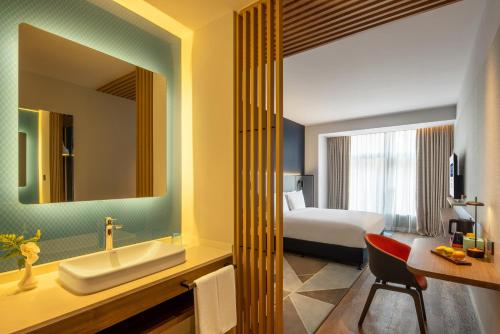 青岛青岛金水智选假日酒店的浴室设有床、水槽和镜子
