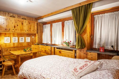 库马约尔Casa-chalet, in centro a Courmayeur!的卧室配有床、桌子和窗户。