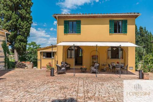 锡耶纳Villa Le Tortore privata lusso piscina relax Siena的黄色的房子,前面设有一个庭院