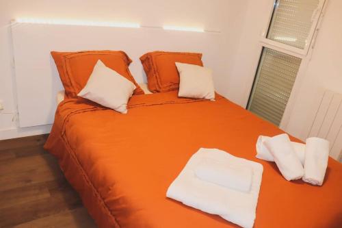 坎佩尔T3 au centre ville avec balcon, parking gratuit的一张带两个枕头的大型橙色床