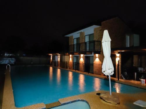 温莎T&V Suites的夜间带白色遮阳伞的游泳池