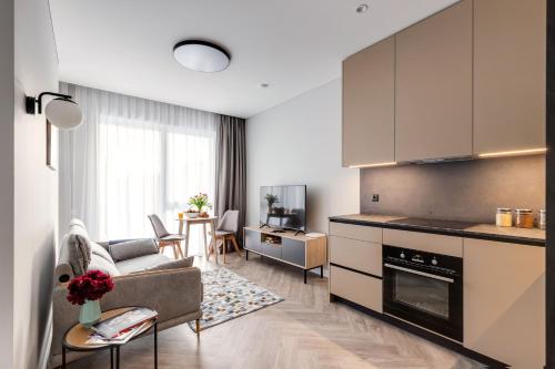 维尔纽斯#stayhere Modern & Compact 1BDR Uptown Vilnius的厨房以及带沙发和桌子的客厅。