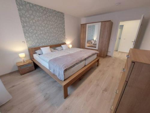 巴特维尔东根Ferienwohnung Helenenquelle的一间卧室设有一张大床,铺有木地板