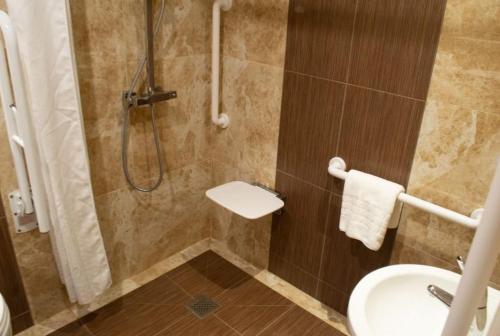 布雷得佛Tong Park Hotel的带淋浴、水槽和卫生间的浴室
