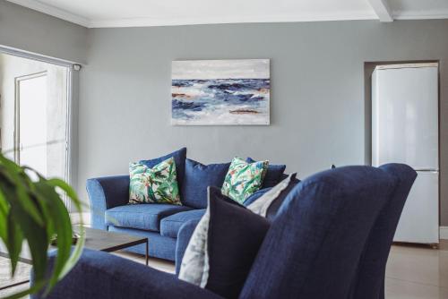 伊丽莎白港Harbour Cottages, Humewood的客厅配有蓝色椅子和蓝色沙发