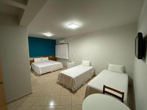 阿西斯Ônix Hotel的一间酒店客房,设有两张床和电视