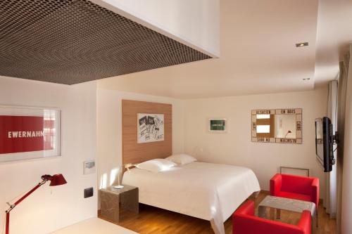 奥贝奈Hotel Le Pavillon 7的一间卧室配有一张床和两张红色椅子
