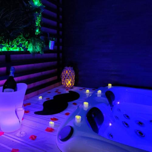 布里夫拉盖亚尔德La Gaillardise - love room - Spa & Sauna - Espace privatif的客房设有带蜡烛和桌子的浴缸。