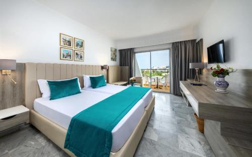 苏塞马哈巴海滩酒店的酒店客房设有一张大床和一张书桌。