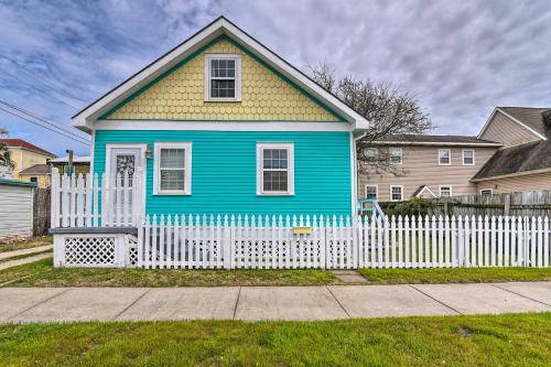 加尔维斯敦Galveston ‘Blue Bungalow’ - Walk to Beach!的蓝色和黄色的房子,有白色的围栏