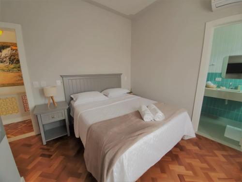 巴拉那瓜Paranaguá Lodge的一间卧室配有两张床和一张带台灯的桌子