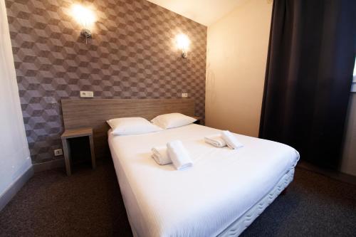克莱蒙费朗比尤利酒店的卧室配有带毛巾的大型白色床