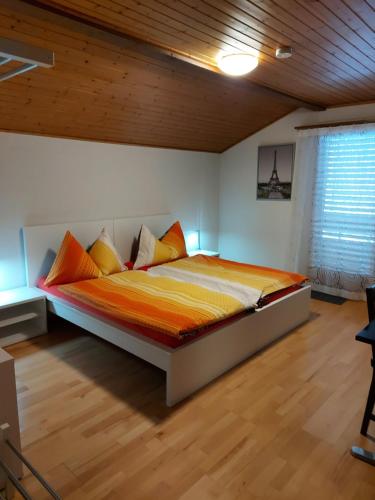 Biberistgood bed biberist BIBERSOL的一间卧室配有橙色和黄色床单