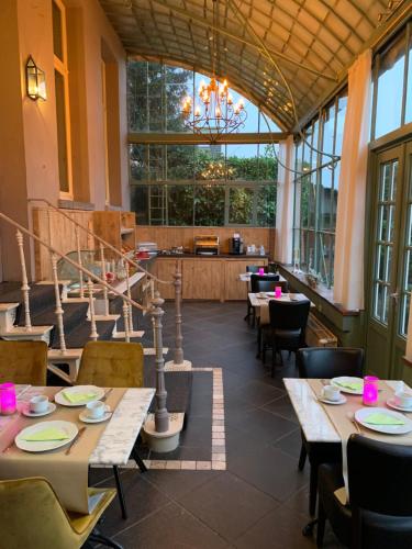达默维尔霍夫酒店的一间带桌椅和吊灯的餐厅