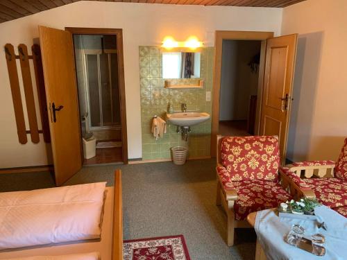 蓬高圣约翰卡斯滕霍夫旅馆的客厅配有沙发和盥洗盆。