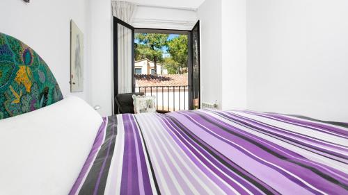雅弗郎其Apartment Sabin - Llafranc的一间卧室配有一张带彩色毯子的床