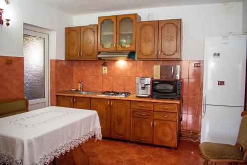 阿列谢尼Cabana Liliana的厨房配有木制橱柜、微波炉和冰箱。